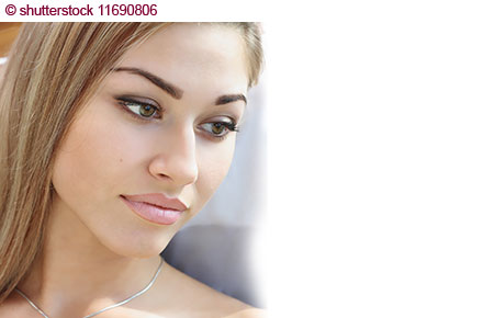 Ein Model schaut verträumt zur Seite. Augenbrauen, Augenlieder und Lippen professionell mit Make-up geschminkt.