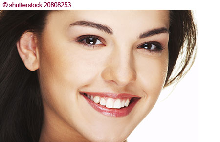 Ein junges Model lächelt natürlich, professionell mit Make-up geschminkt.